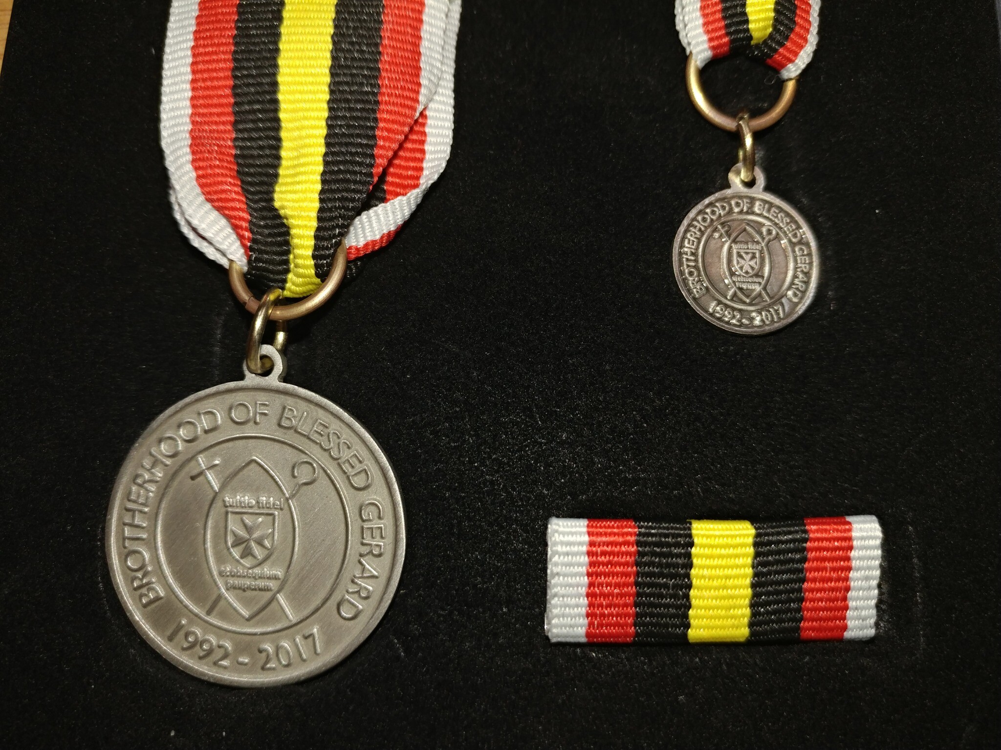 Reverse of the 2017 Brotherhood of Blessed Gérard Medal of Merit bearing the Brotherhood emblem and the dates 1992 to 2017